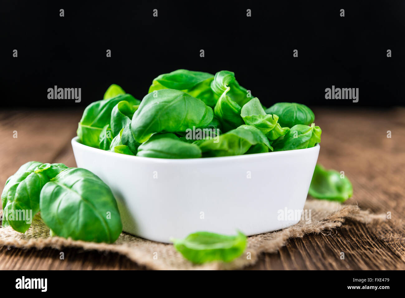 Portion of fresh Basil leaves (selective focus; close-up shot) on wooden background Stock Photo