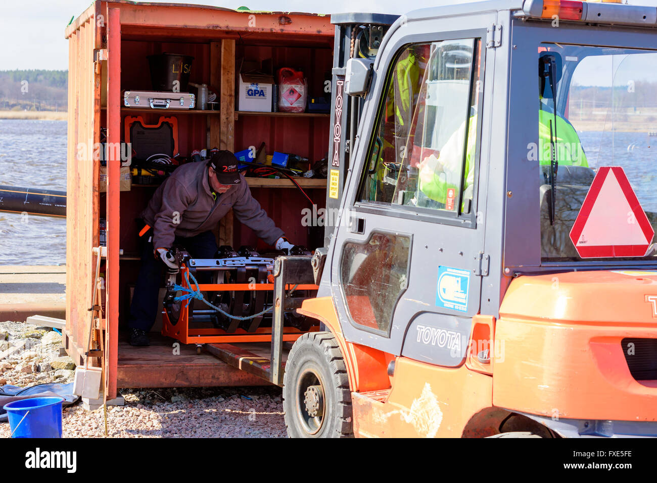 Karlskrona, Sweden - April 7, 2016: Assembly of underwater sewage pipeline in public area. Here two workers transport a mounting Stock Photo