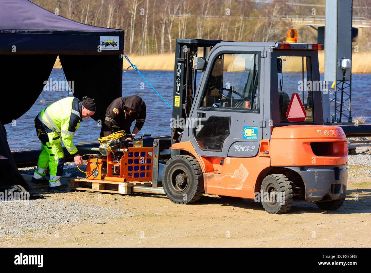 Karlskrona, Sweden - April 7, 2016: Assembly of underwater sewage pipeline in public area. Here workers are loading a pallet for Stock Photo