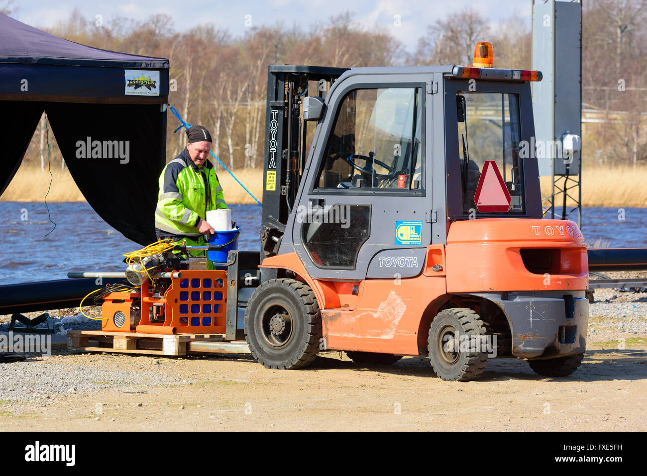 Karlskrona, Sweden - April 7, 2016: Assembly of underwater sewage pipeline in public area. Here workers are loading a pallet for Stock Photo