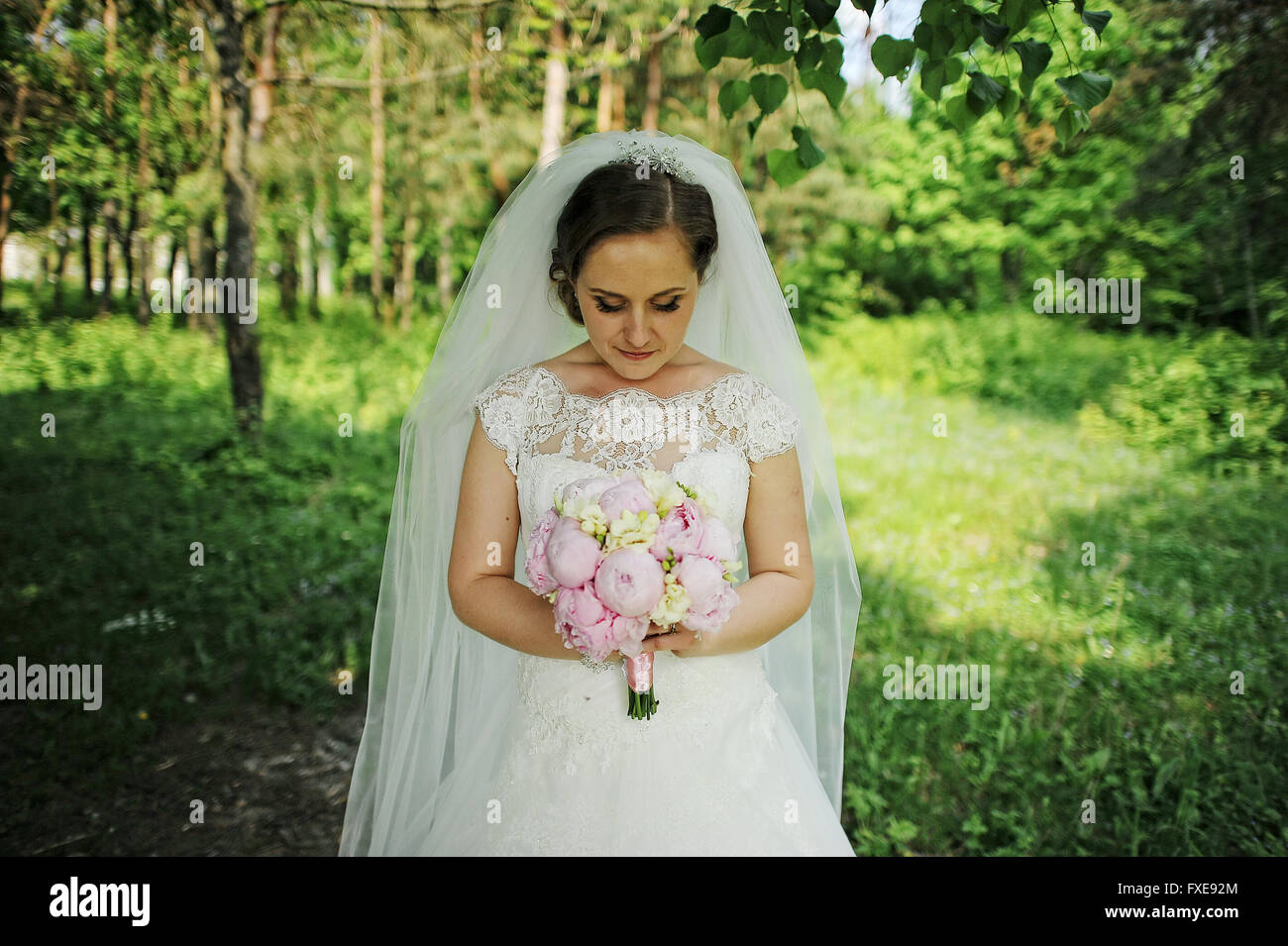 Portrait of cute bride with peony wedding bouquet at hands Stock Photo ...