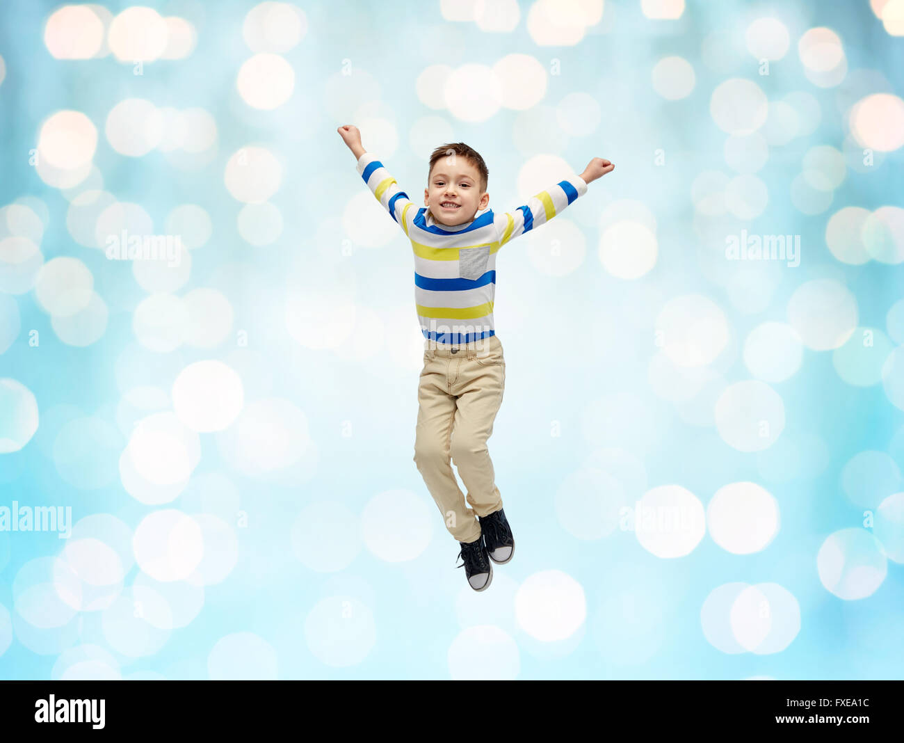 happy little boy jumping in air over blue lights Stock Photo - Alamy