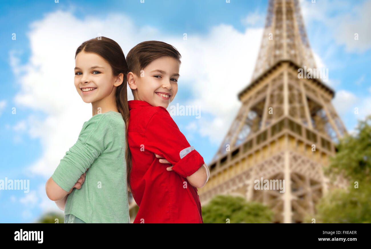 happy boy and girl standing over eiffel tower Stock Photo