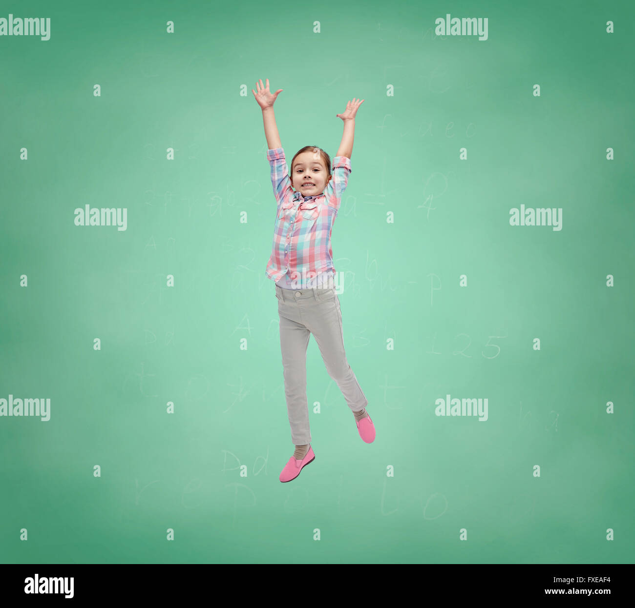 happy little girl jumping in air over school board Stock Photo - Alamy