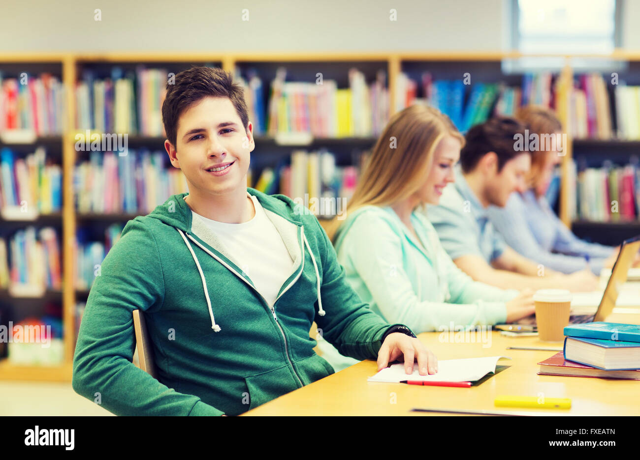 happy student boy reading books in library Stock Photo - Alamy