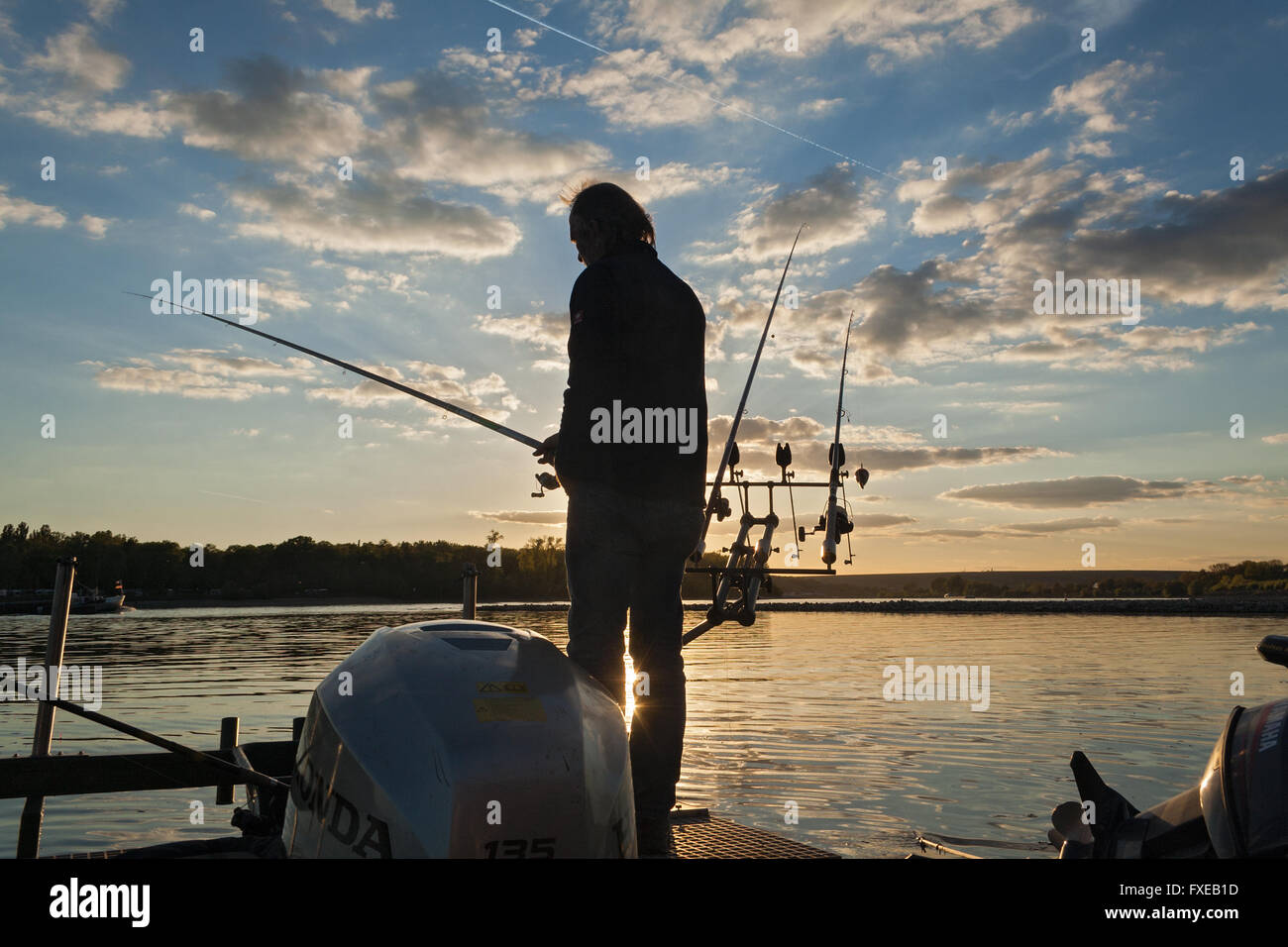 fisherman in sunset on the banks of the Rhine River, Germany Stock Photo