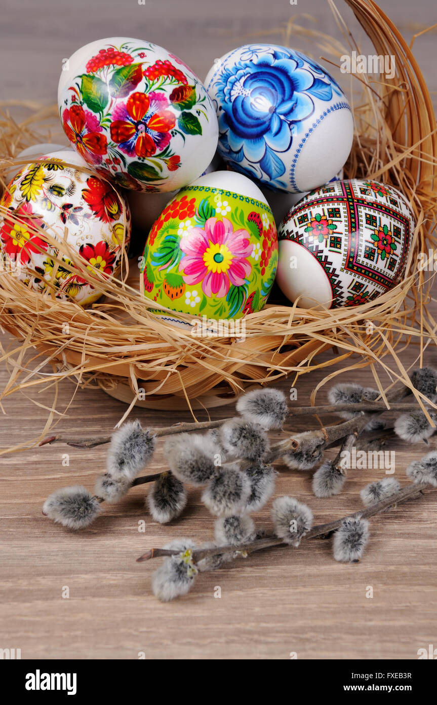 A variety of painted Easter eggs in a basket with willow branches Stock ...