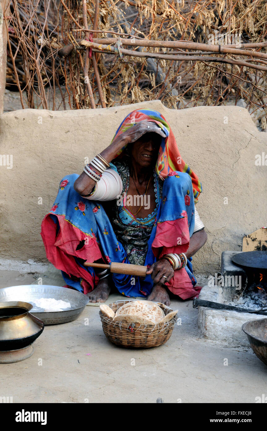 A woman sits making her early morning breakfast chapatis in a village near the northern Indian town of Jojawar. Stock Photo