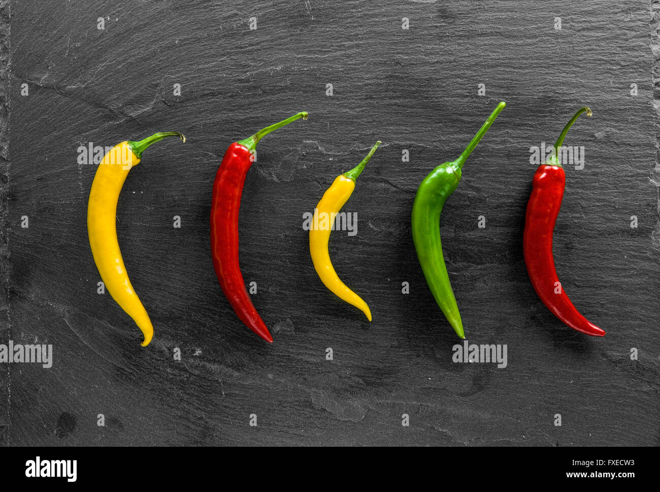 Hot chili peppers on slate plate. Stock Photo