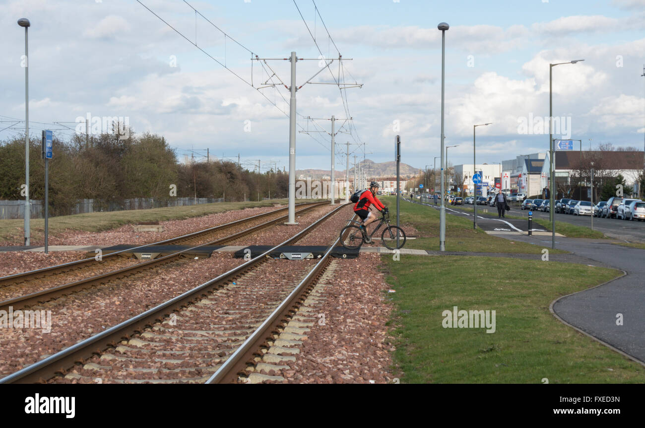 Edinburgh tramlines track,  rail section towards Arthur's Seat,  with cyclist on crossing point. Stock Photo