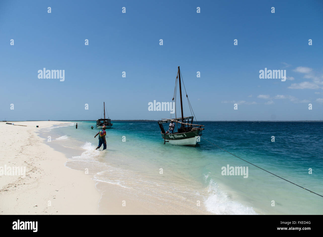 Private boat tour guides working off the sandy beach in the Indian ocean, Tanzania Stock Photo