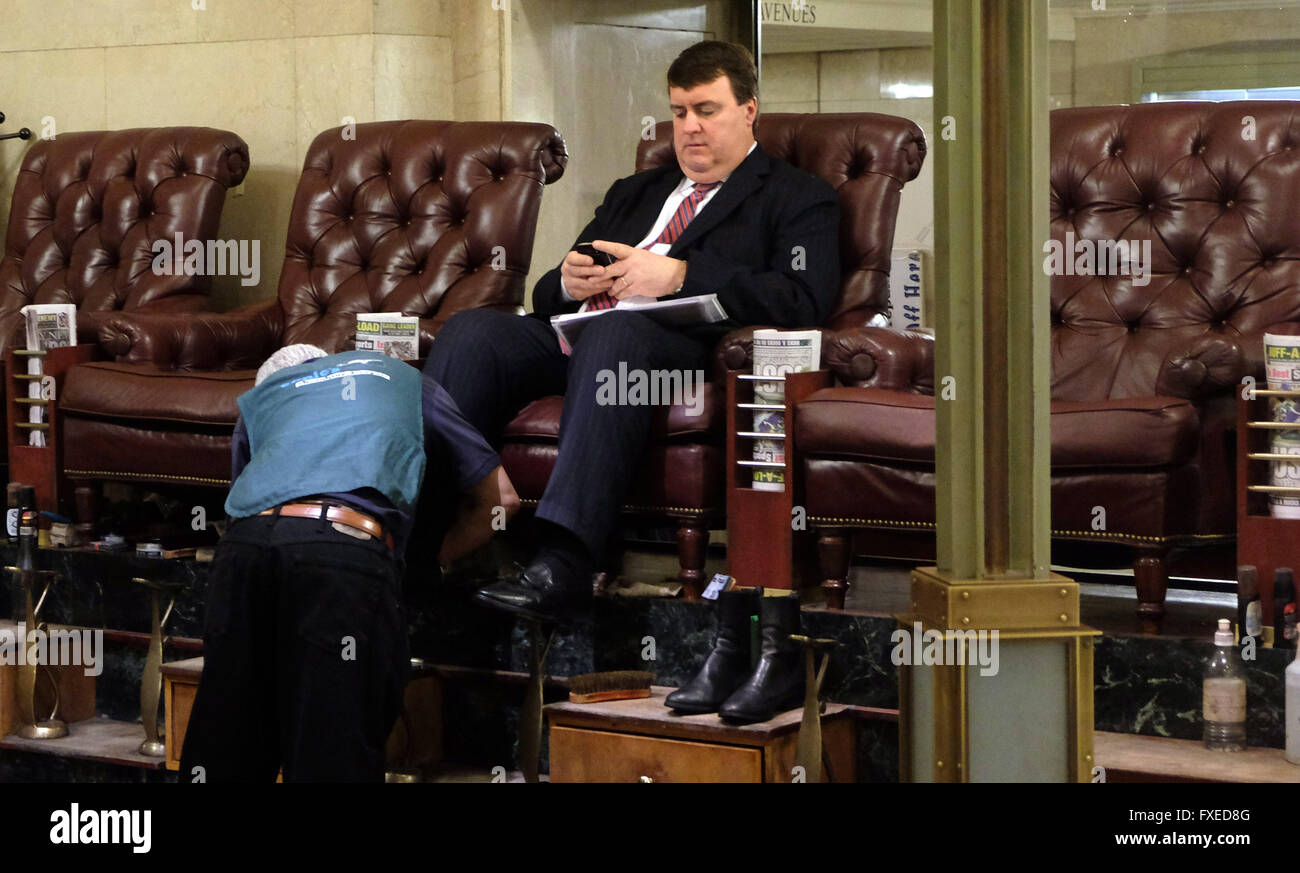 A business man gets his shoes polished in Central Station in New York, United States of America. Stock Photo