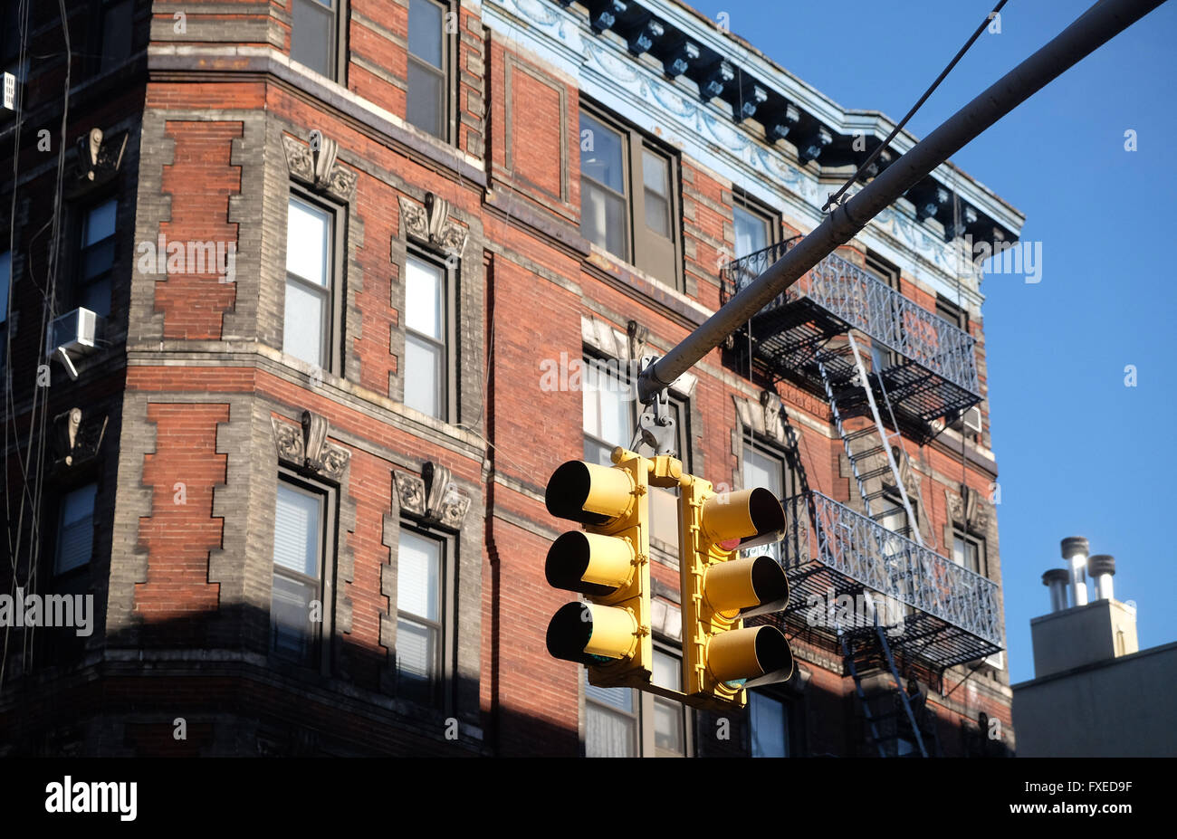 A street scene of sun on a mansion block and traffic lights in Manhattan, New York City, United States of America. Stock Photo