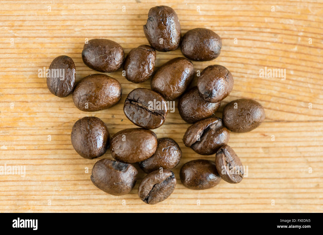 Close-up of several whole roast Espresso coffee beans on a wooden surface. Stock Photo