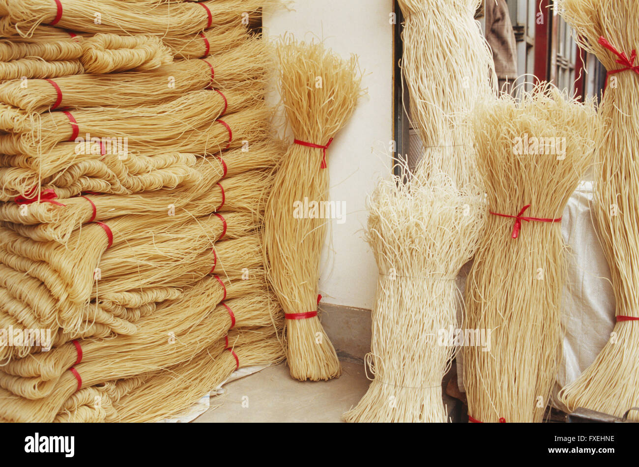 China, Gansu, Linxia, bunches of dry noodles tied with red ribbons and ready for sale. Stock Photo