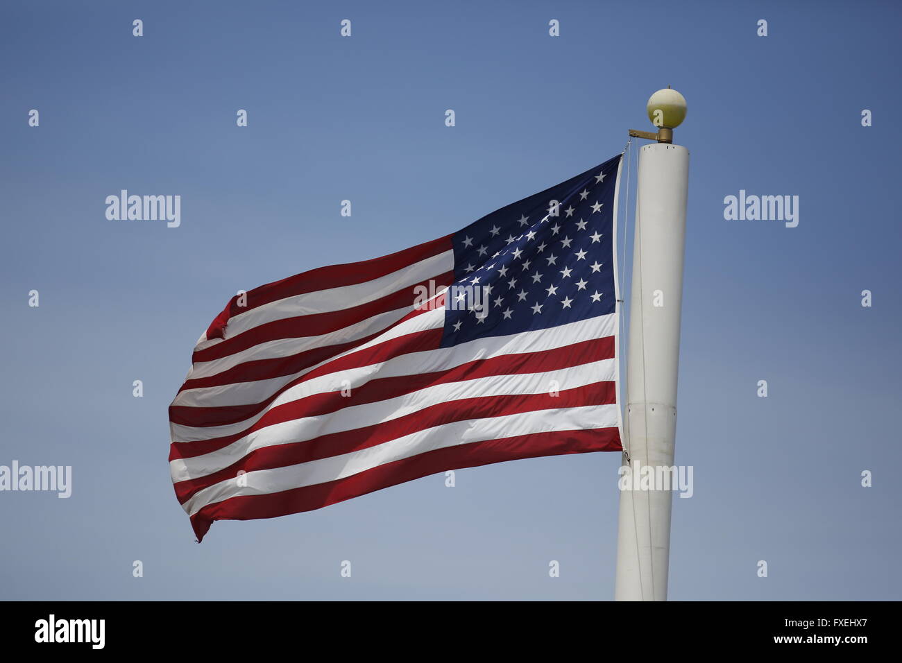 Unites States flag flying on cell phone tower. Stock Photo