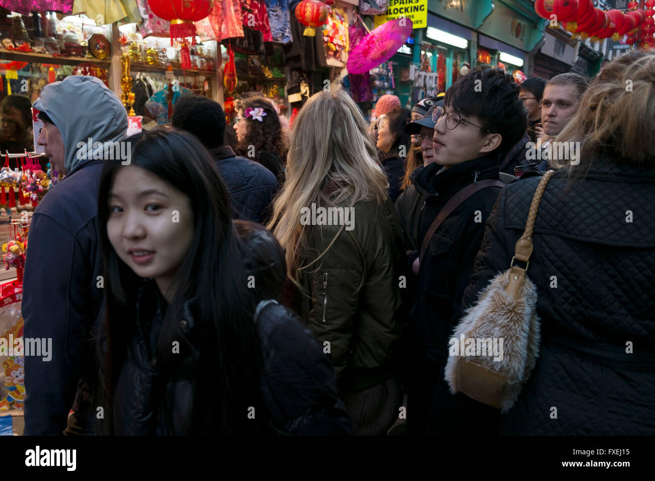 Crowds of people squeeze into a narrow street Chinatown during Chinese New Year celebrations in central London, United Kingdom. Tens of thousands of people gathered in the West End filling the streets and joining in with the festival atmosphere. Stock Photo