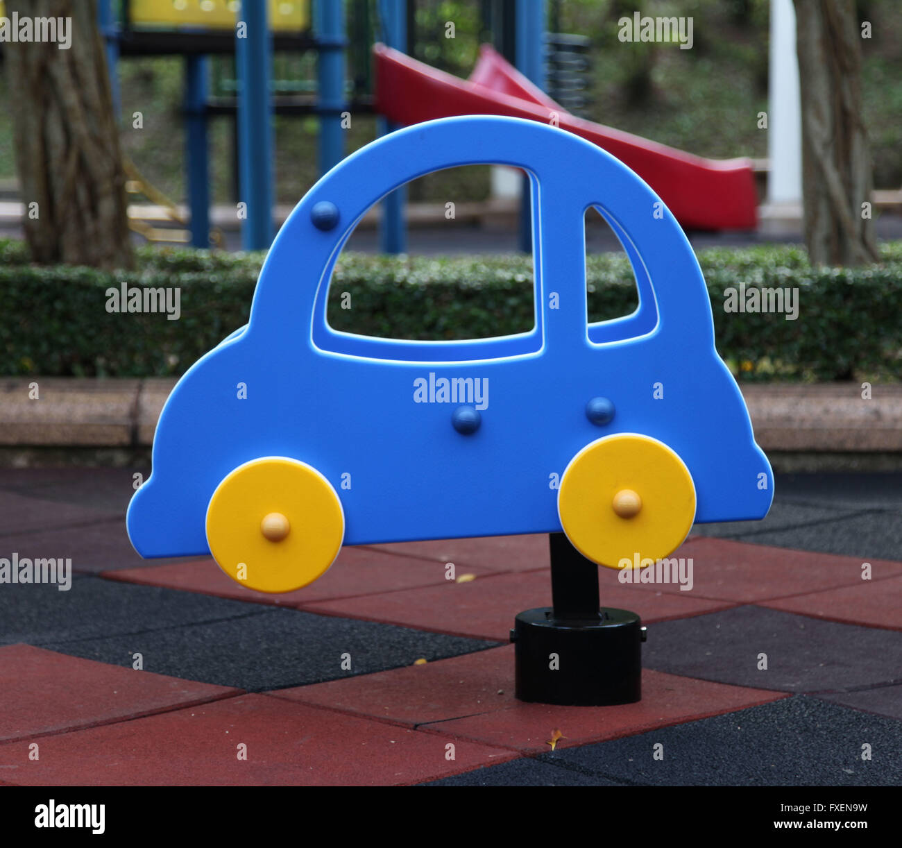 It's a photo of a small blue car swing for kids to play n a kid's playground. Stock Photo
