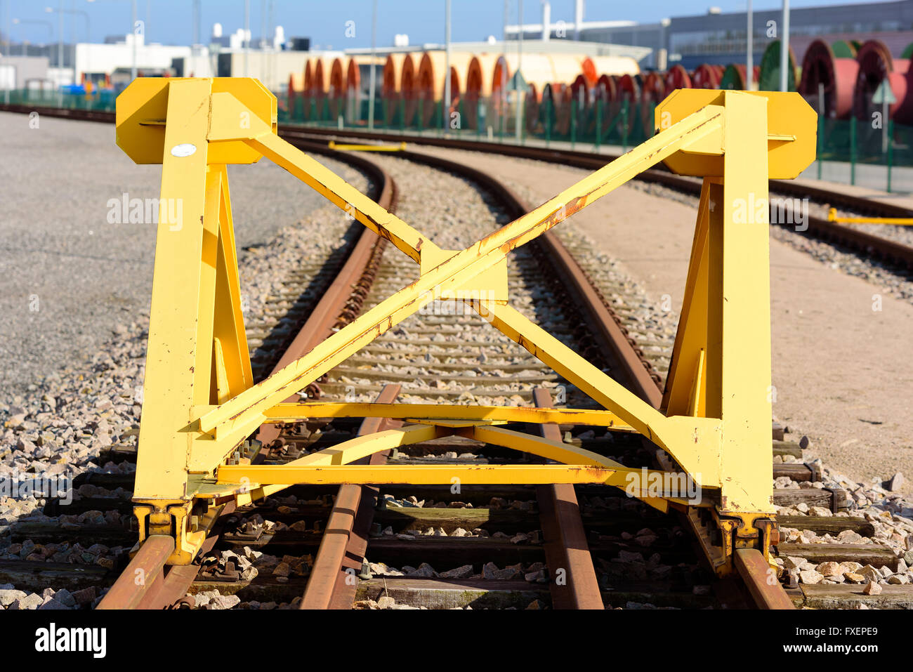 Bright yellow train buffer stop or bumper at the end of a railway track