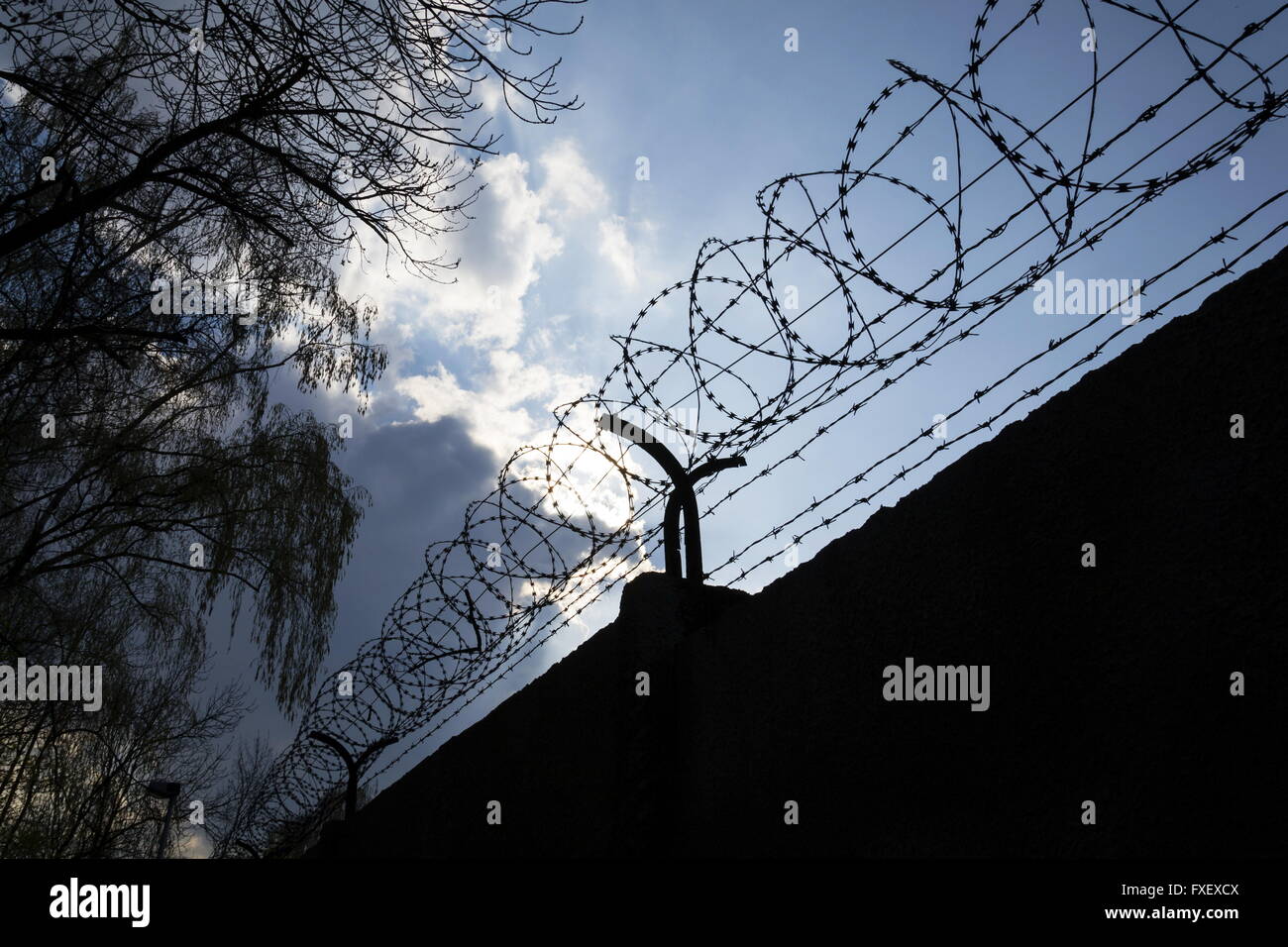 Dramatic clouds behind barbed wire fence on a prison wall Stock Photo ...