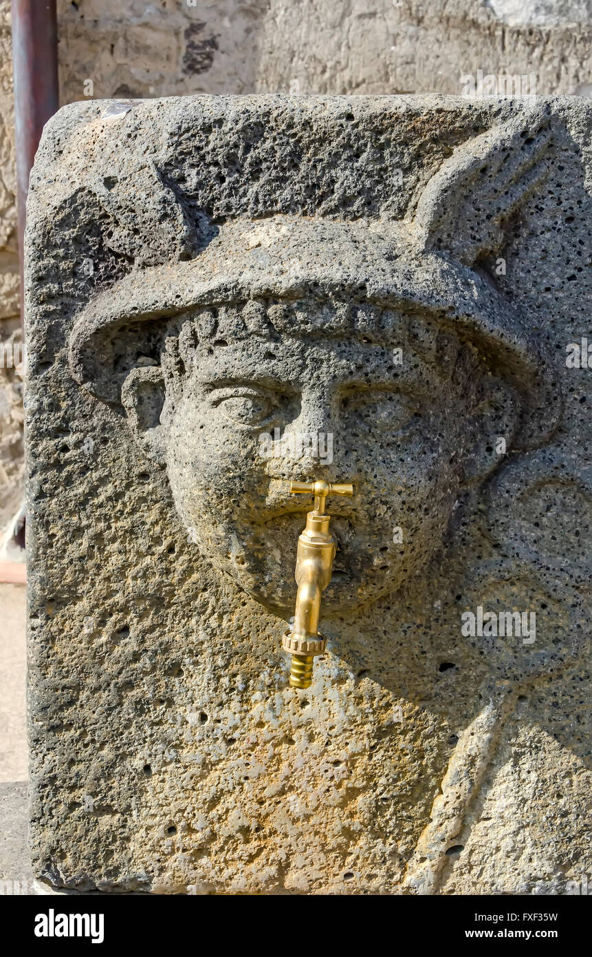 Ancient Roman Stone water fountain with modern spiqot at  Pompeii ruins archaeological site Italy. Stock Photo