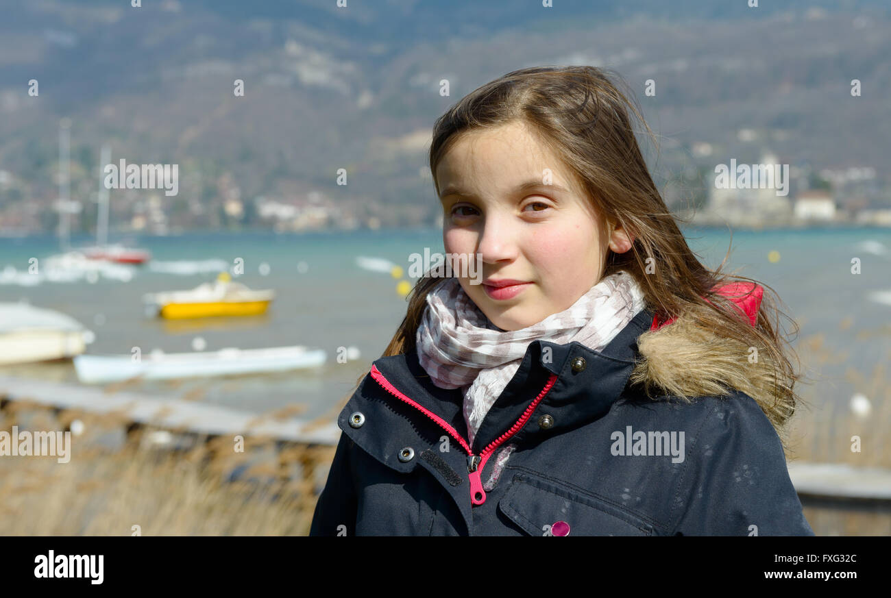 Outdoor portrait of a little girl in a black jacket lake background Stock Photo