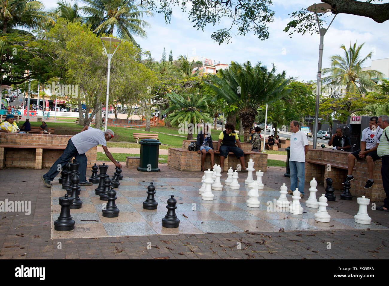 Local men playing chess outside in the park. Noumea, New Caledonia, South Pacific. Stock Photo