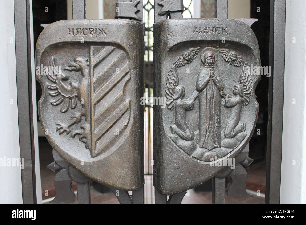 coats of arms with symbols of city on eagle--Nyasvij, praying Mother Mary--Minsk on gate of cemetery,September,23 Minsk, Belarus Stock Photo