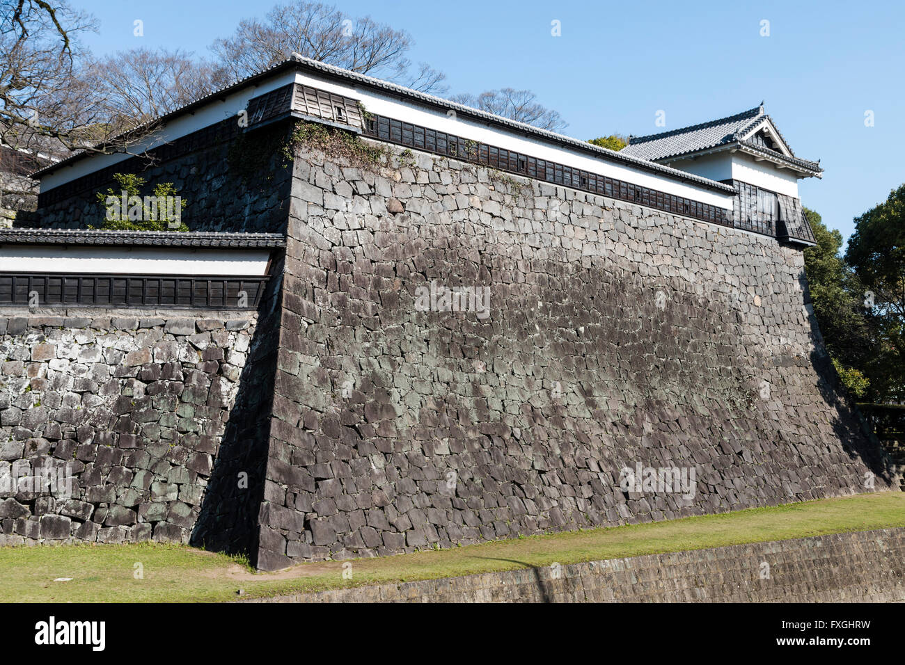 Kumamoto castle, Japan. High stone walls, Ishigaki, with Hira Onyagura, yagura, turret, at end. Walls feature dobei tops, wood and plaster roofed wall. Stock Photo