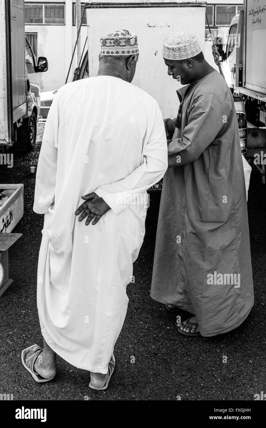 Omani Men In Traditional Costume Chatting At The Fish Market, Muttrah, Muscat, Sultanate Of Oman Stock Photo