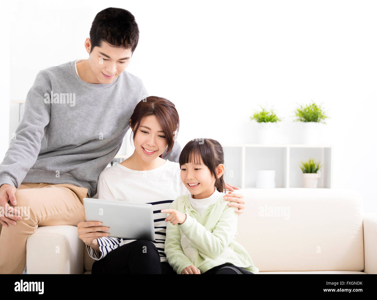 Happy Attractive Young  Family watching the tablet Stock Photo