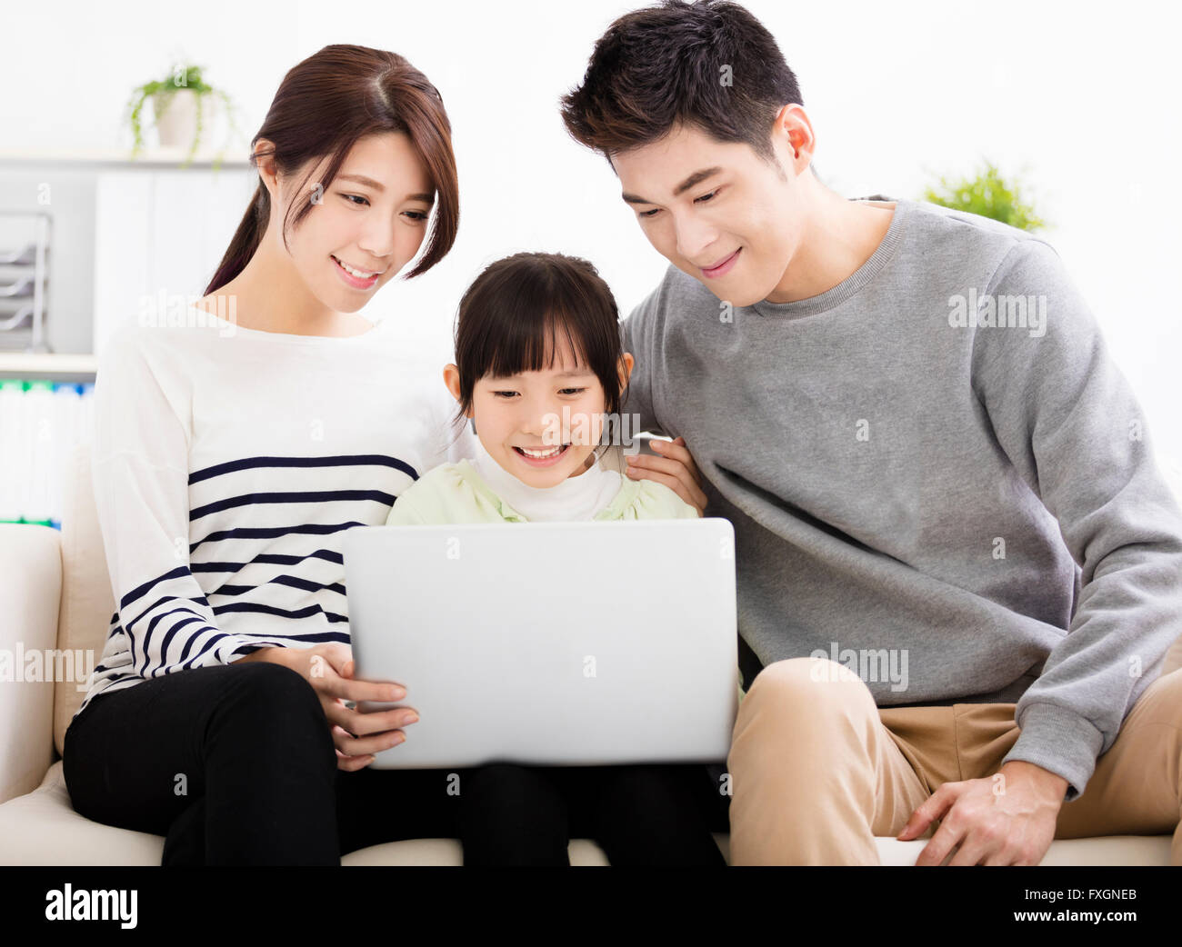 Happy Attractive Young  Family watching the laptop Stock Photo