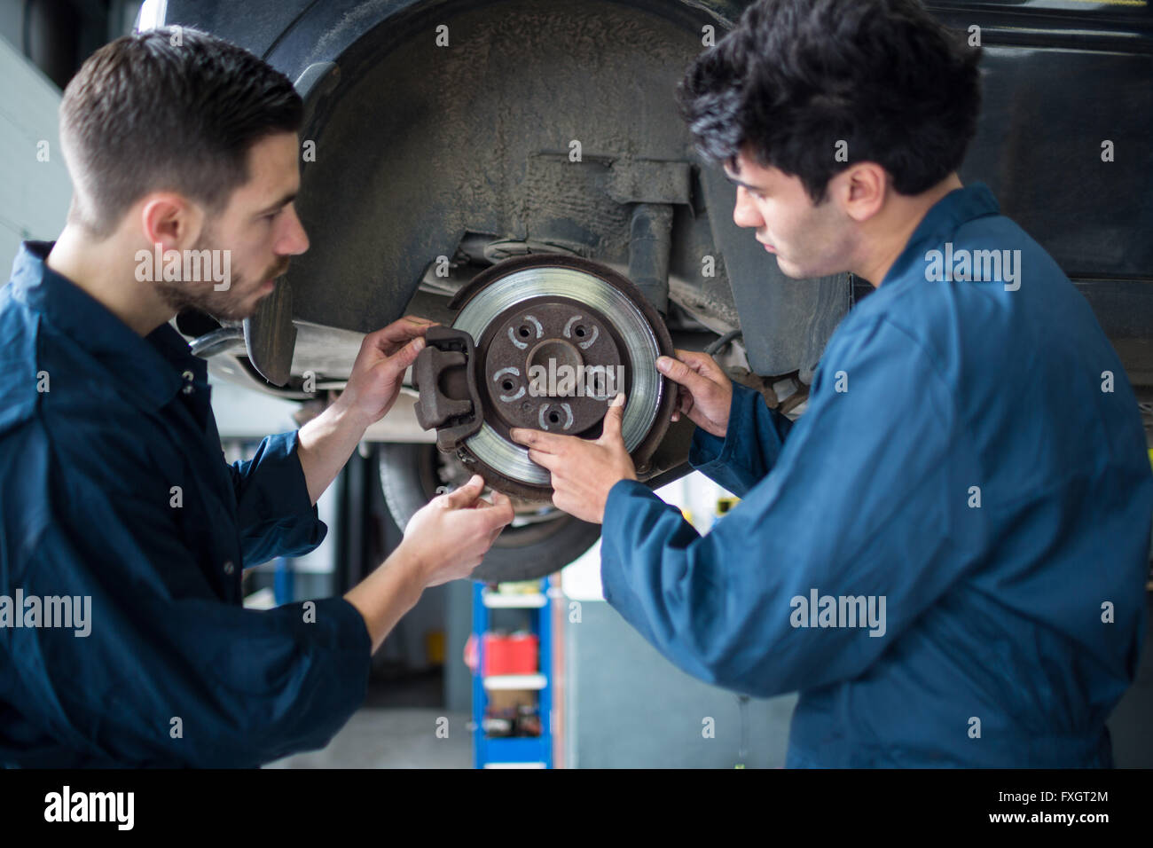 Mechanics examining car brake Stock Photo