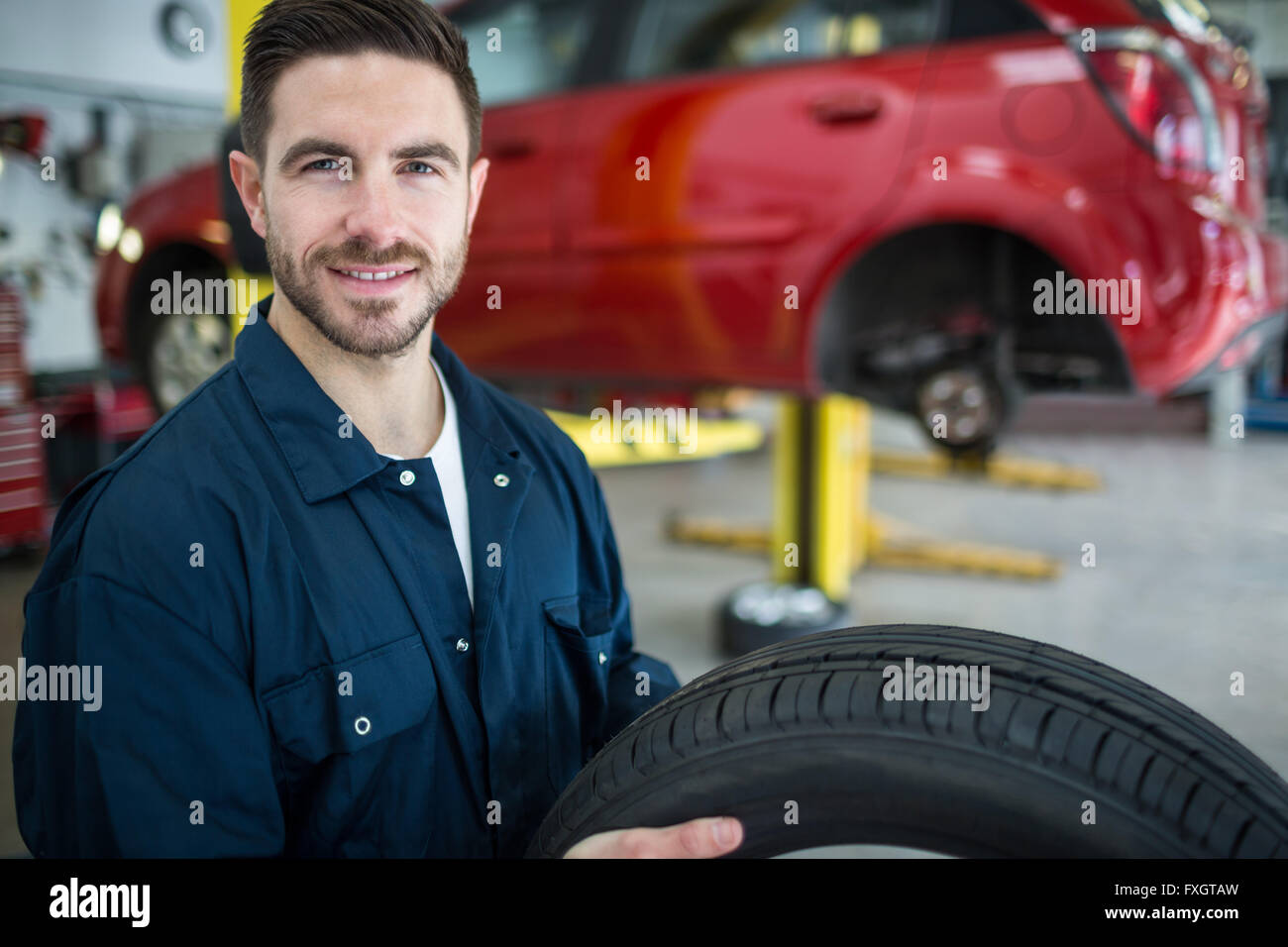 Mechanic holding tyre Stock Photo Alamy