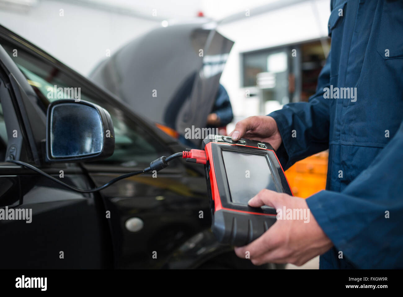 Mechanic using a diagnostic tool at the repair garage Stock Photo Alamy
