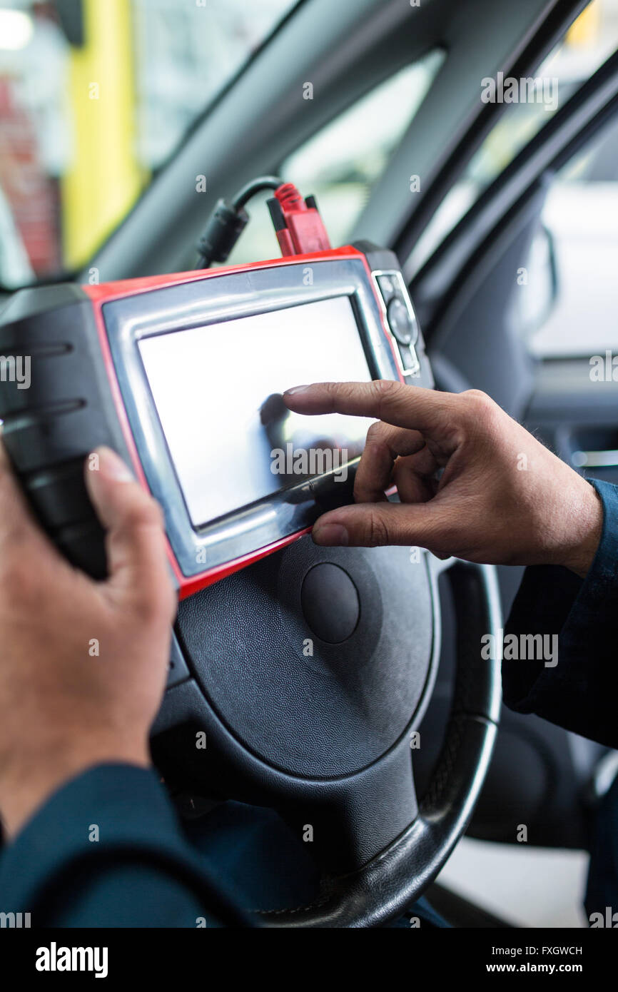 Mechanic using a diagnostic tool Stock Photo