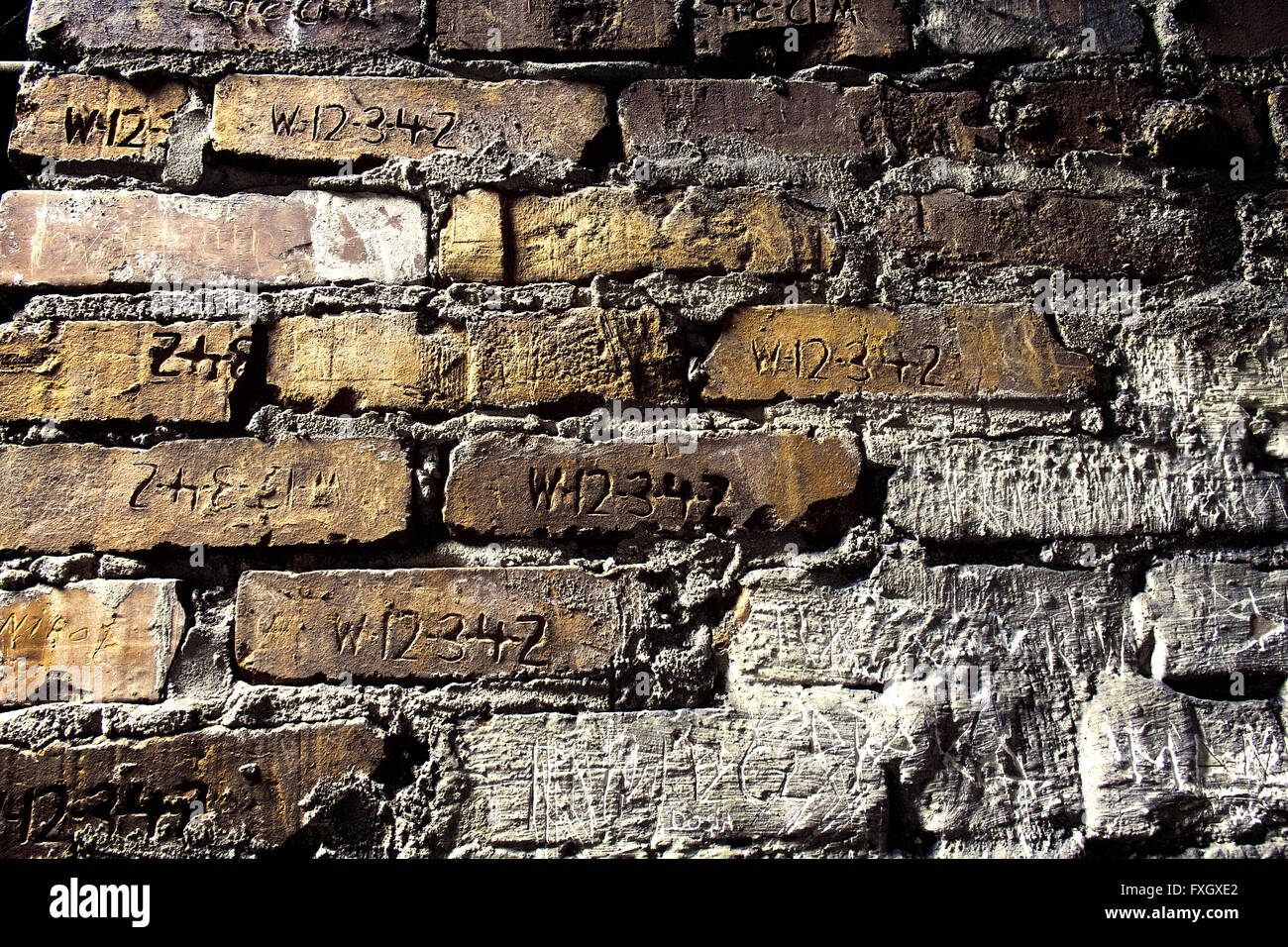 Inside Auschwitz-Birkenau, Poland, engraved prisoner numbers in the brickwork Stock Photo