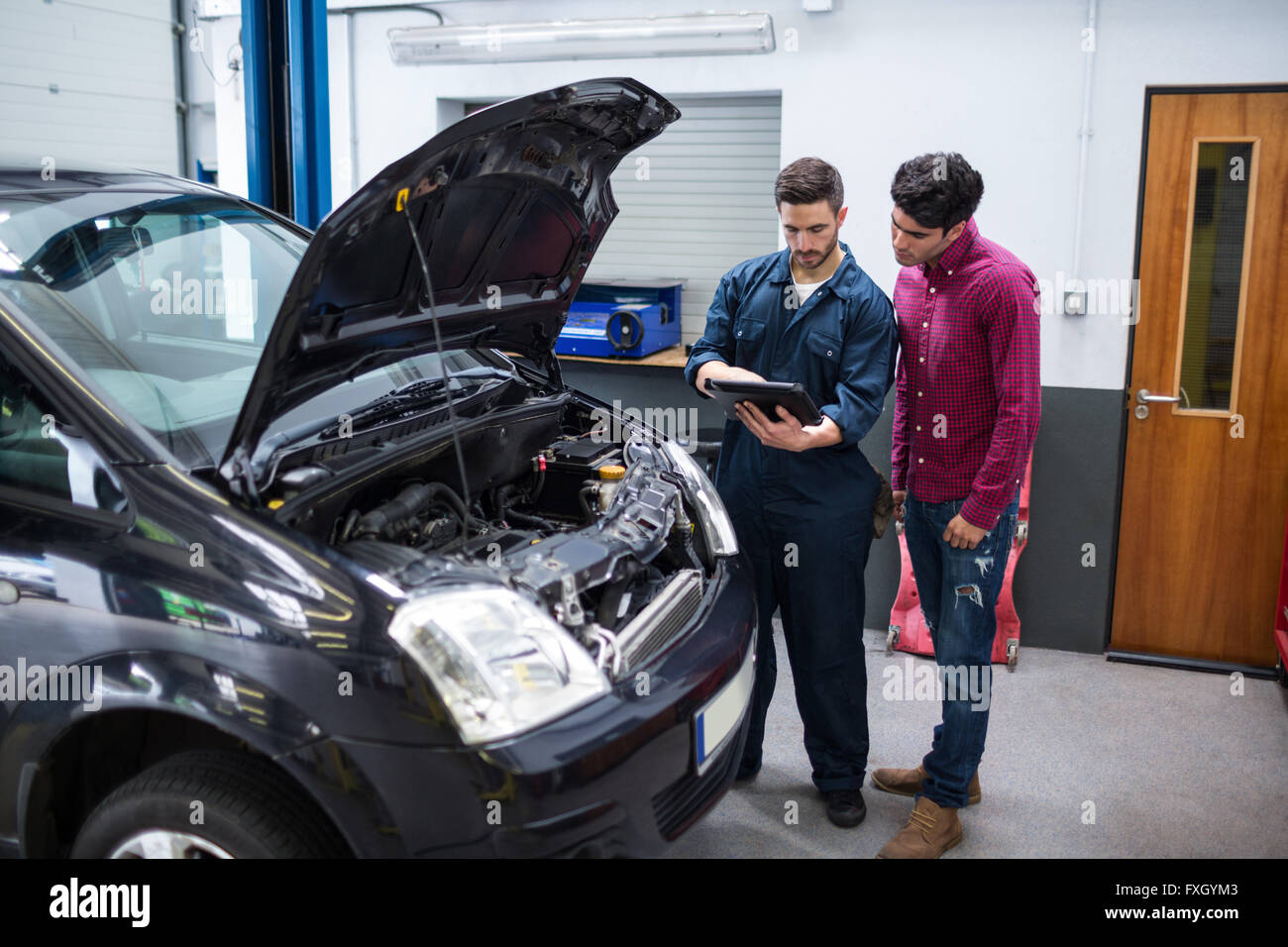 Mechanic showing customer the problem with car using diagnostic tool Stock Photo Alamy
