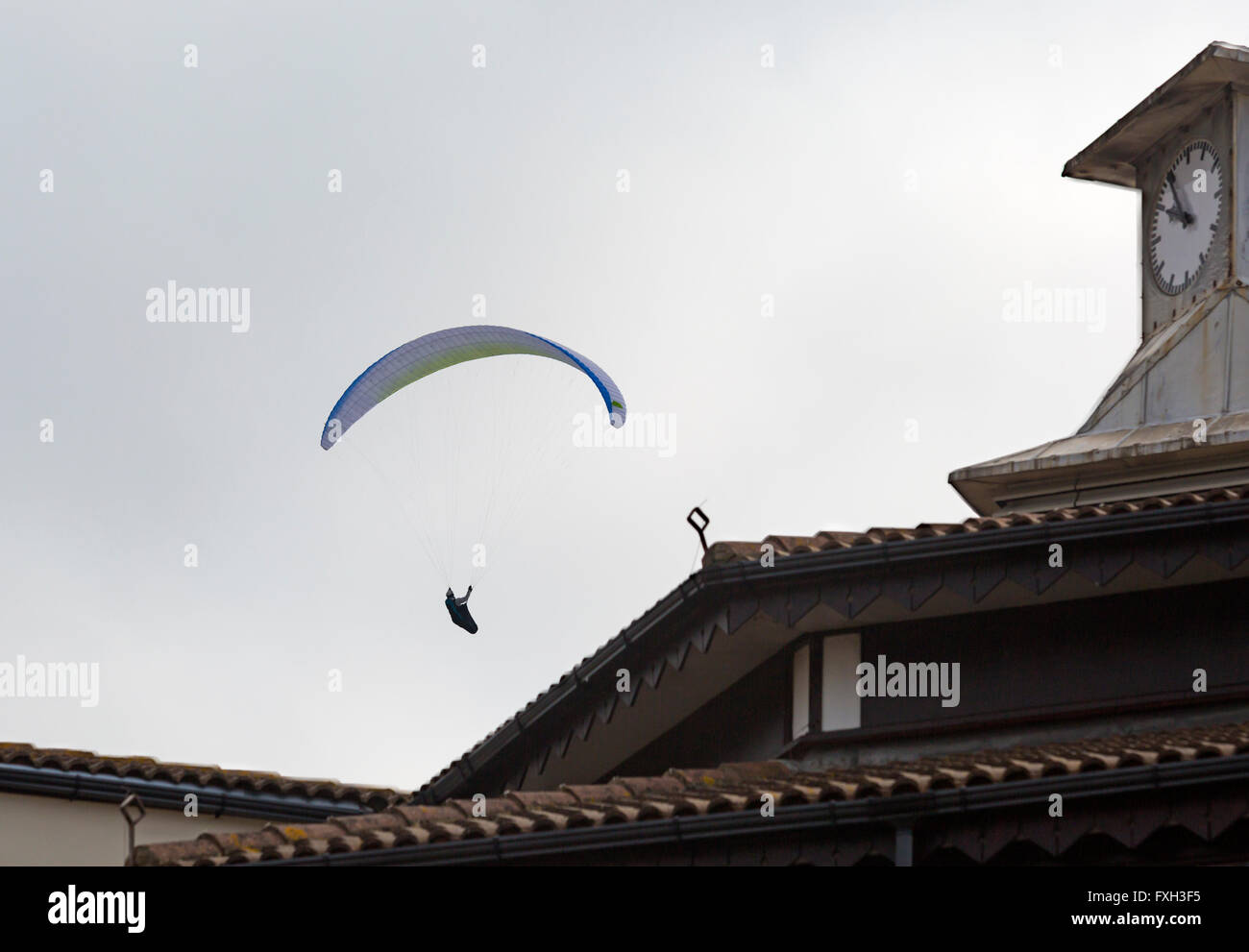 Paraglider glides past clock tower on Bournemouth Pier, Bournemouth, Dorset  UK in April - paragliding Stock Photo