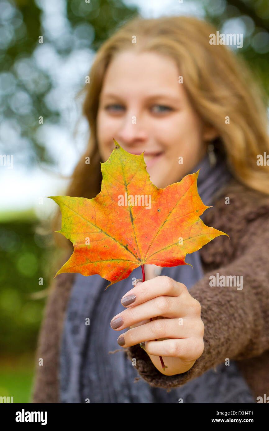 Girl in fall with autumn leaf in the hand Stock Photo