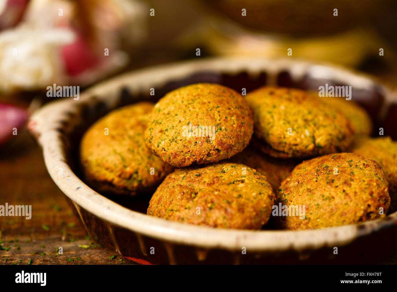 closeup of an earthenware plate with some falafel on a rustic wooden table Stock Photo