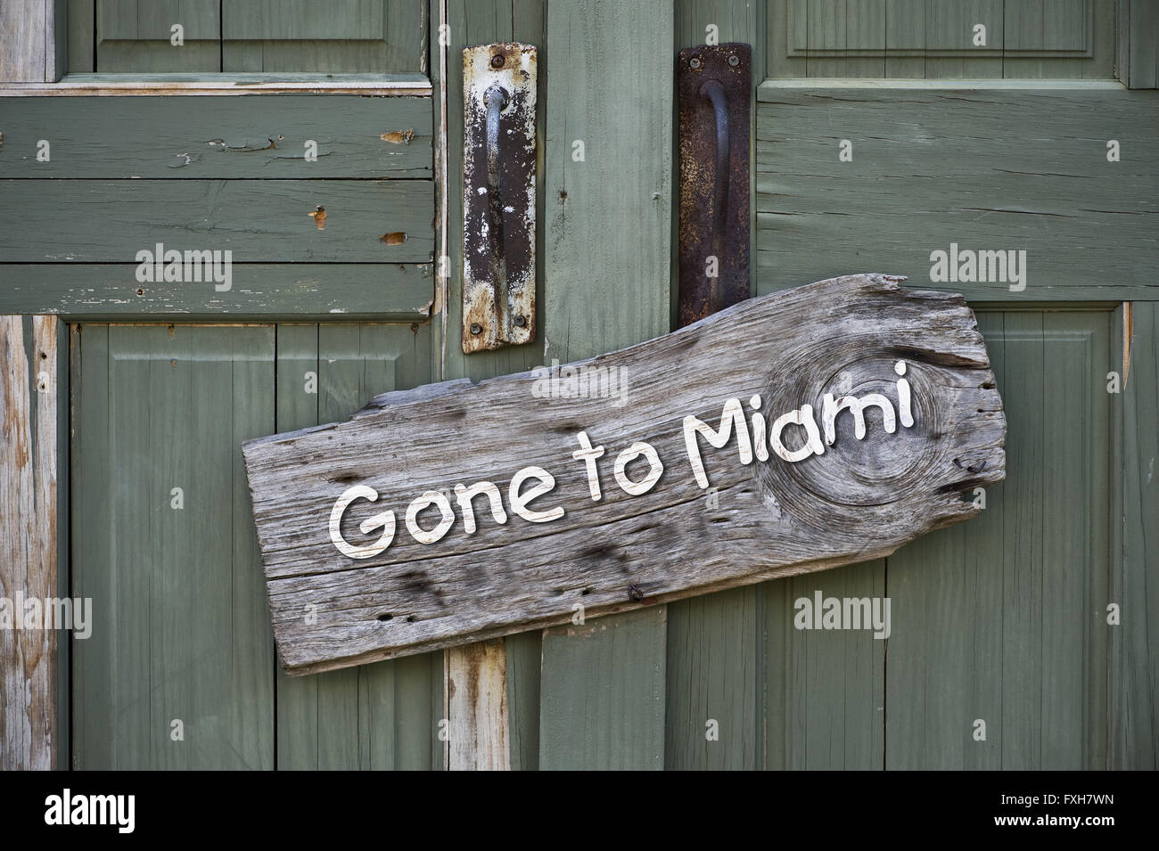 Gone to Miami sign on old green doors. Stock Photo