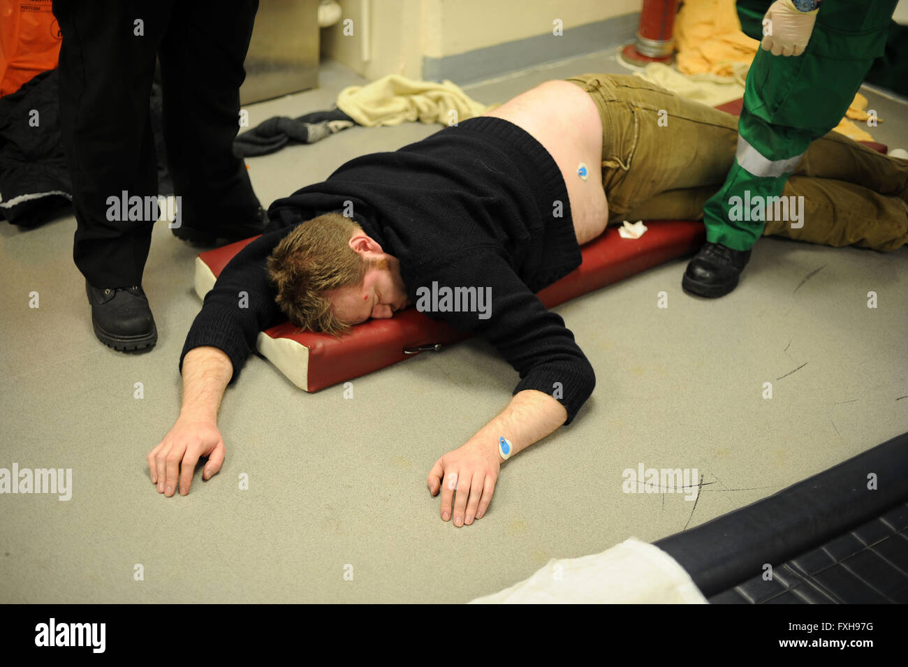 Paramedics provide first aid treatment to a drunken drunk man on black friday in Cardiff, South Wales. Stock Photo