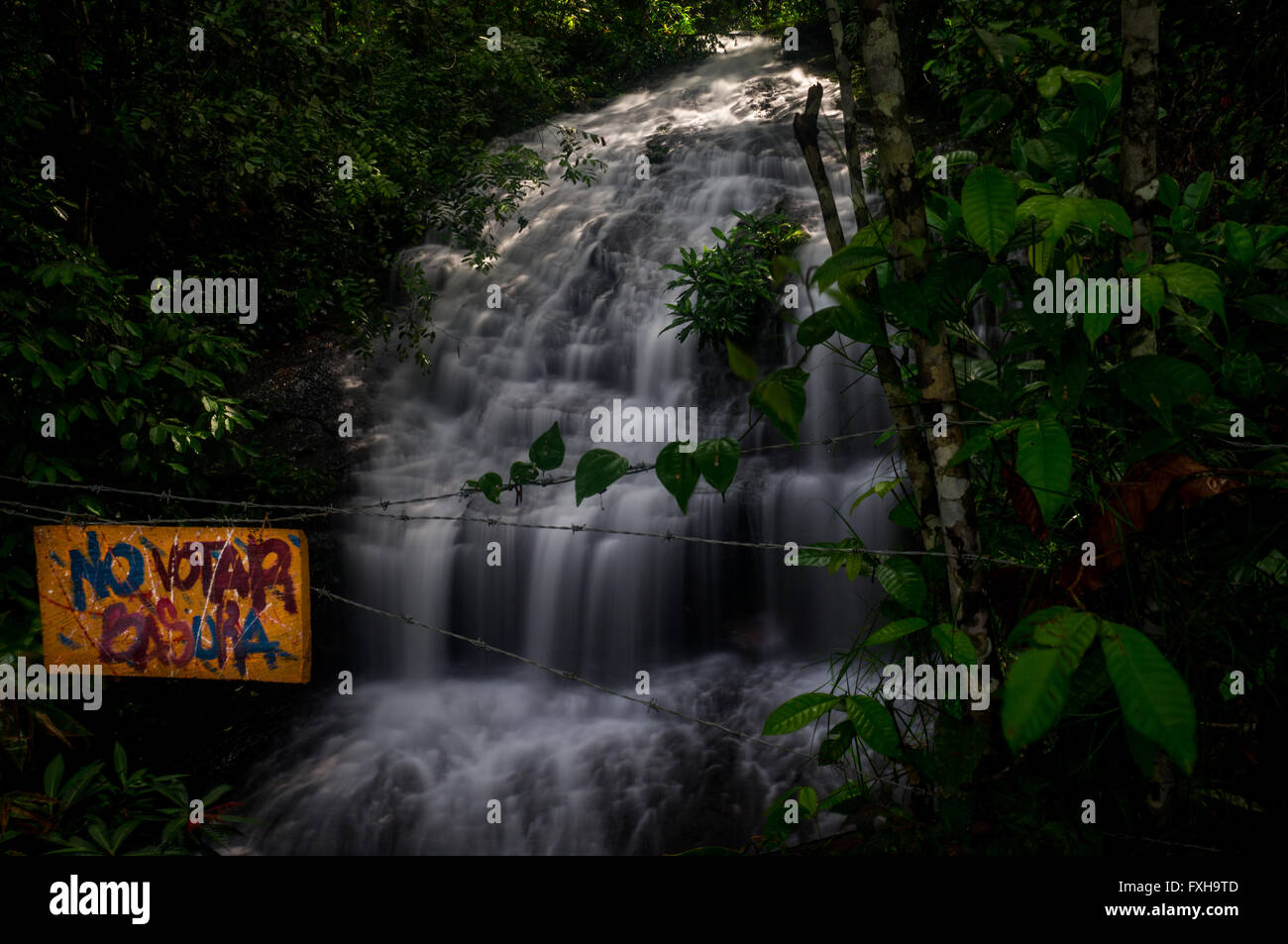Colombia in December 2015: A Spanish sign reading No Votar Basura urges the visitor of a beautiful waterfall not to pollute the Stock Photo