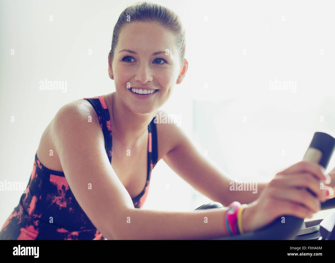 Smiling woman riding exercise bike at gym Stock Photo Alamy