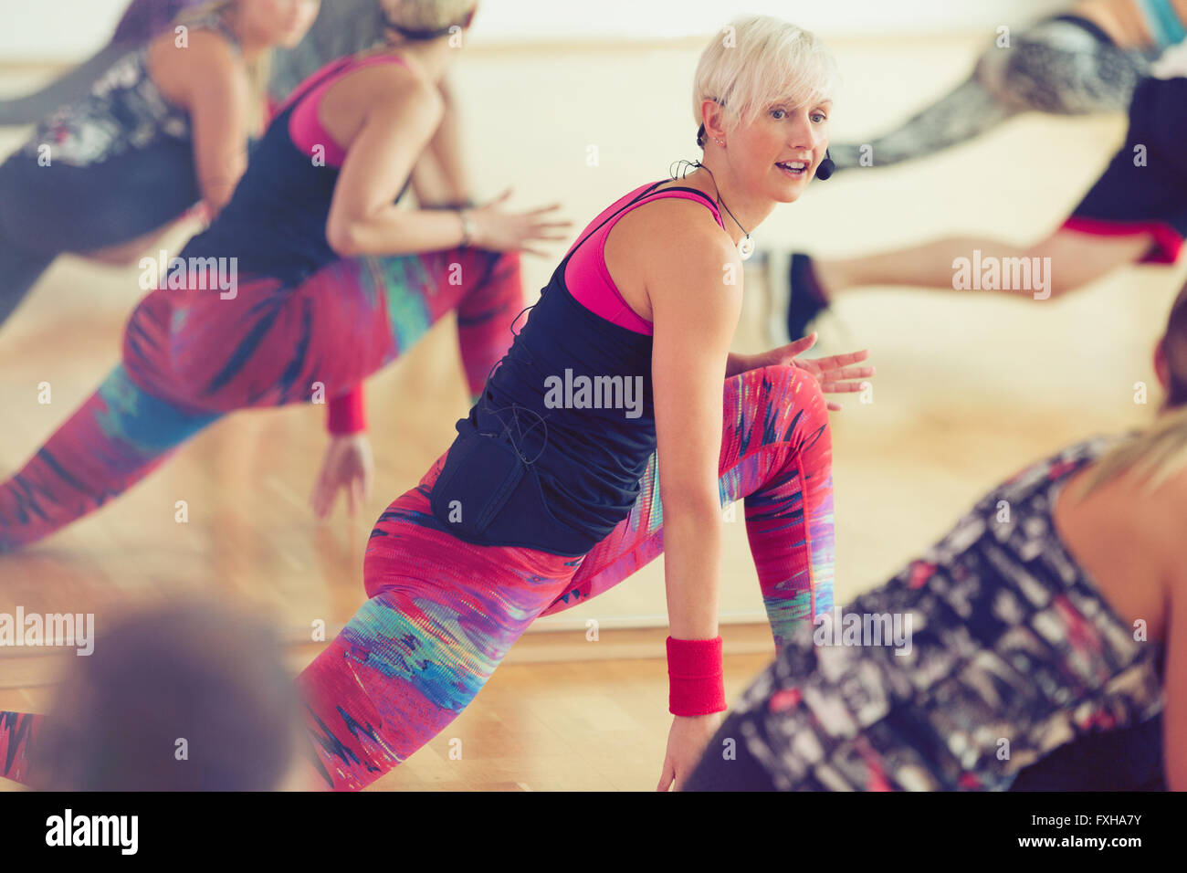 Fitness instructor leading class in lunge Stock Photo