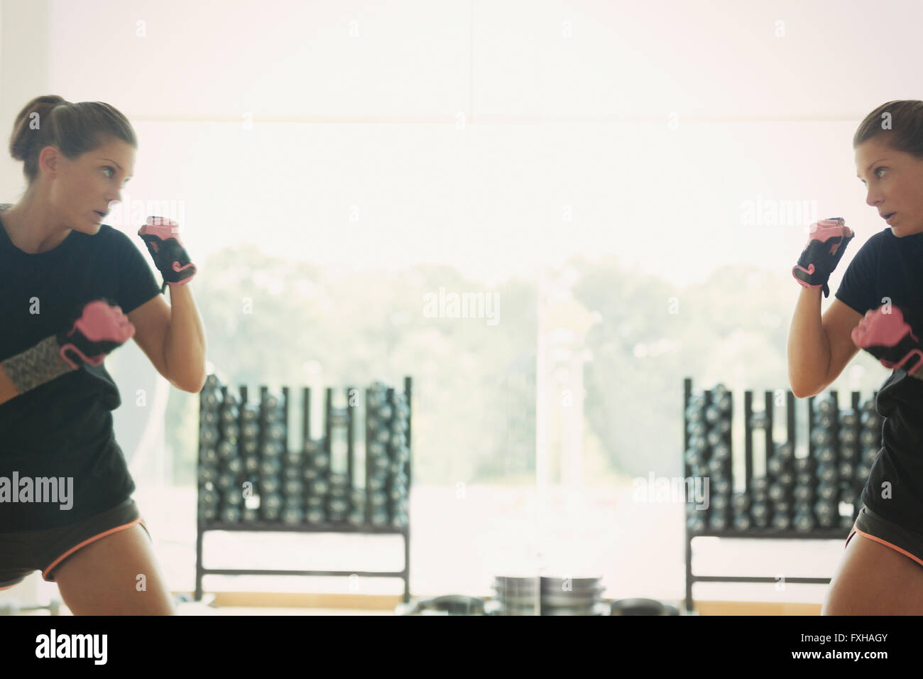 Reflection of woman shadow boxing at gym studio mirror Stock Photo