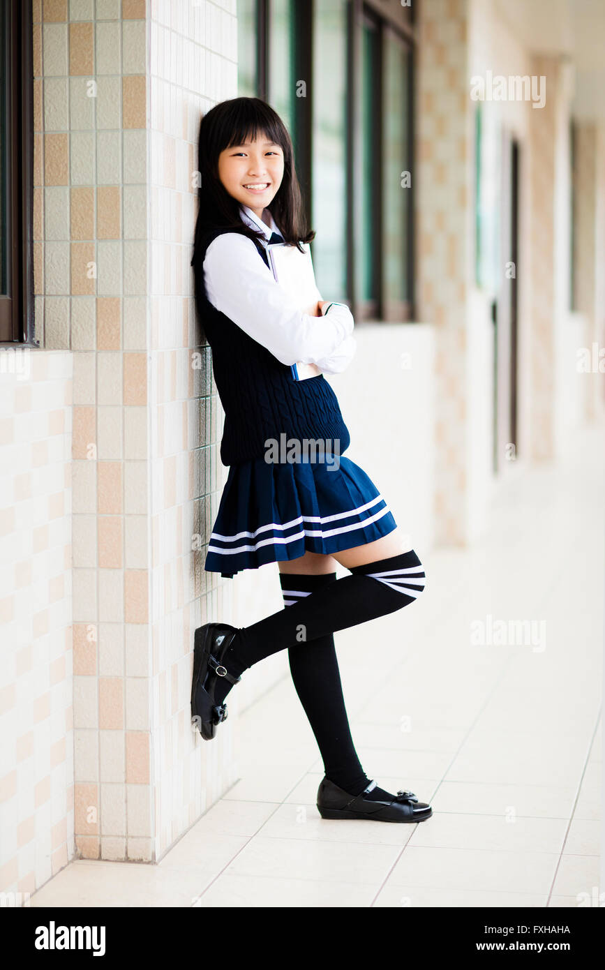 pretty  student girl holding books in front of  classroom Stock Photo