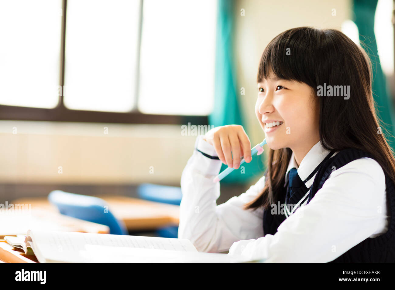 happy pretty  student girl with books in classroom Stock Photo