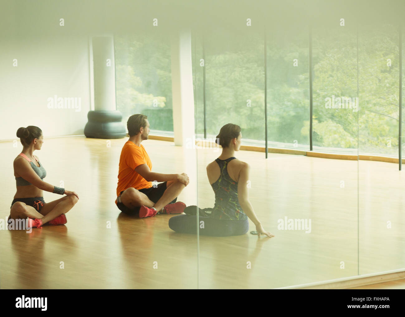 Man and women doing twisted stretch in gym studio Stock Photo
